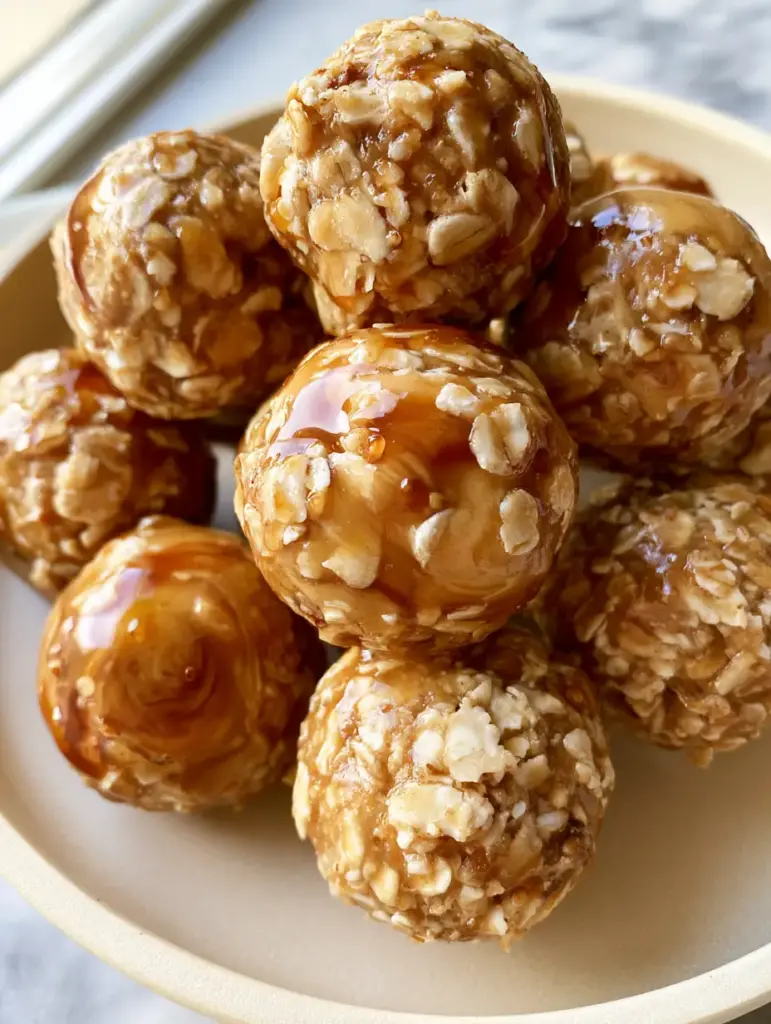 A close-up pile of energy bites on a matte cream plate with soft natural morning light.