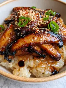 Extreme close-up of glossy shiitake mushrooms with charred edges over translucent sticky rice. (mushrooms with sticky rice)
